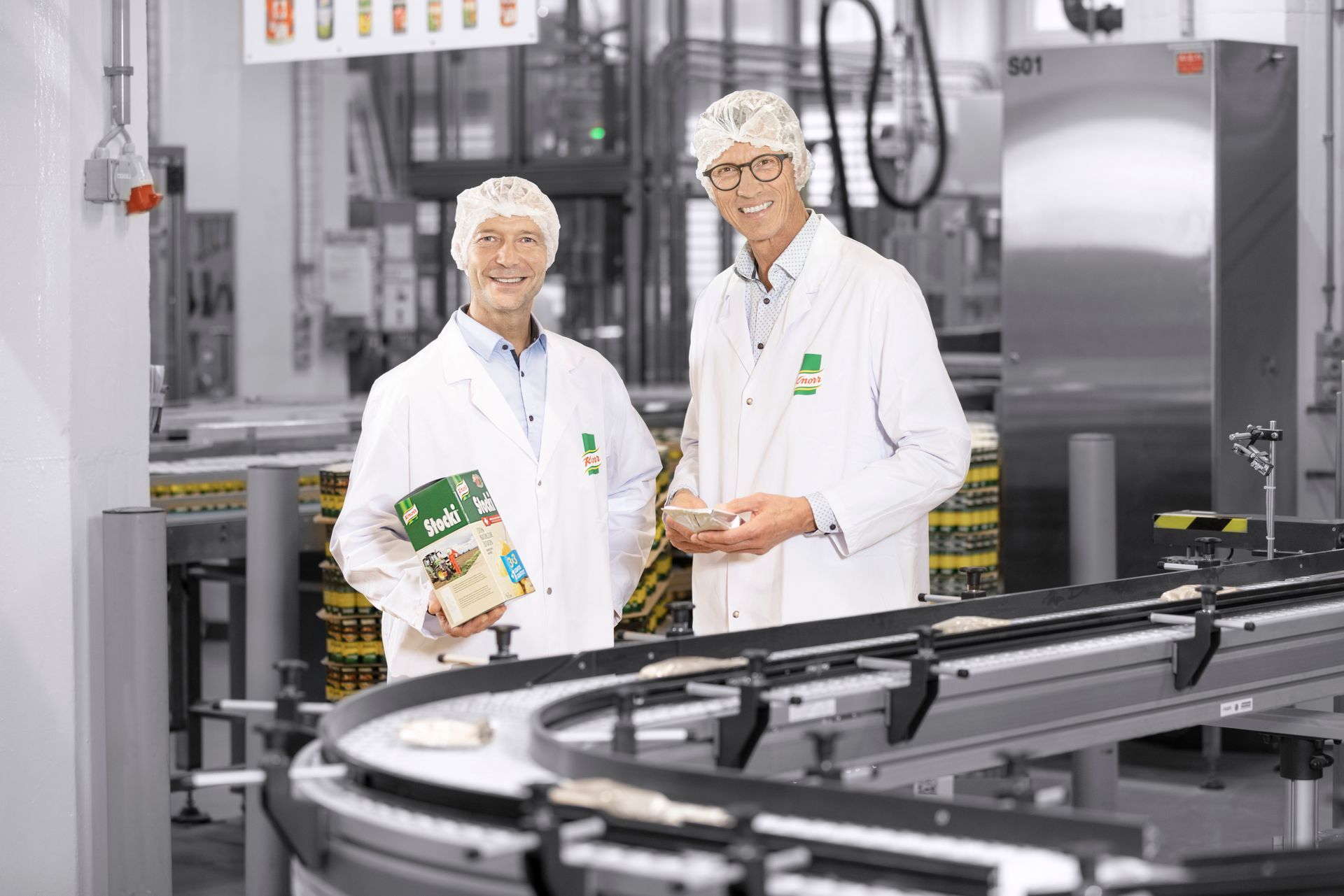 Two men are standing next to each other in the Unilever factory.
