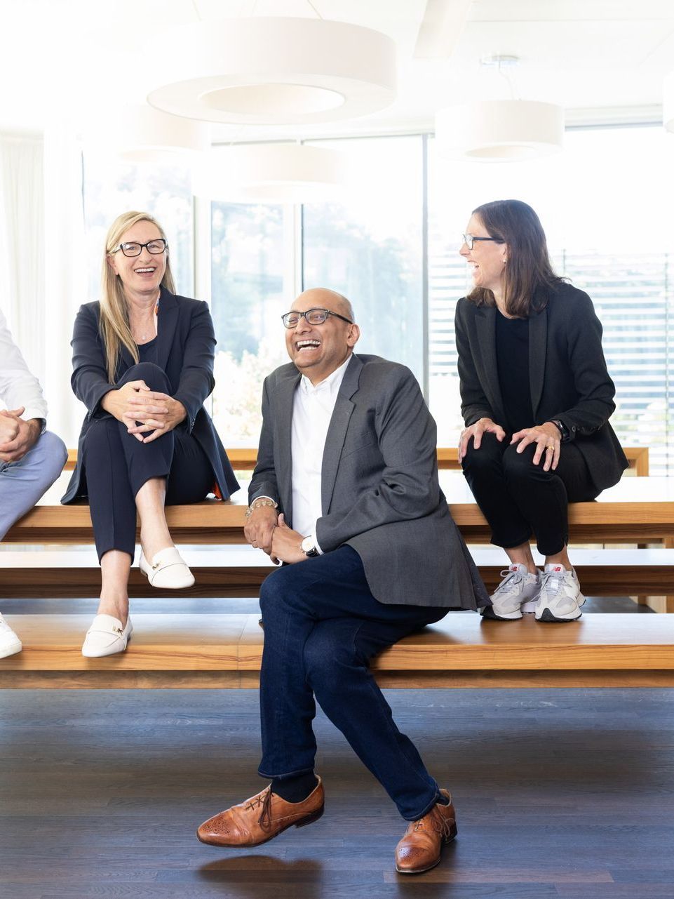 A group of people are sitting on a wooden bench.