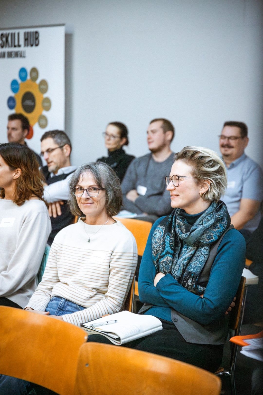 Eine Gruppe von Menschen sitzt auf Stühlen in einem Raum.
