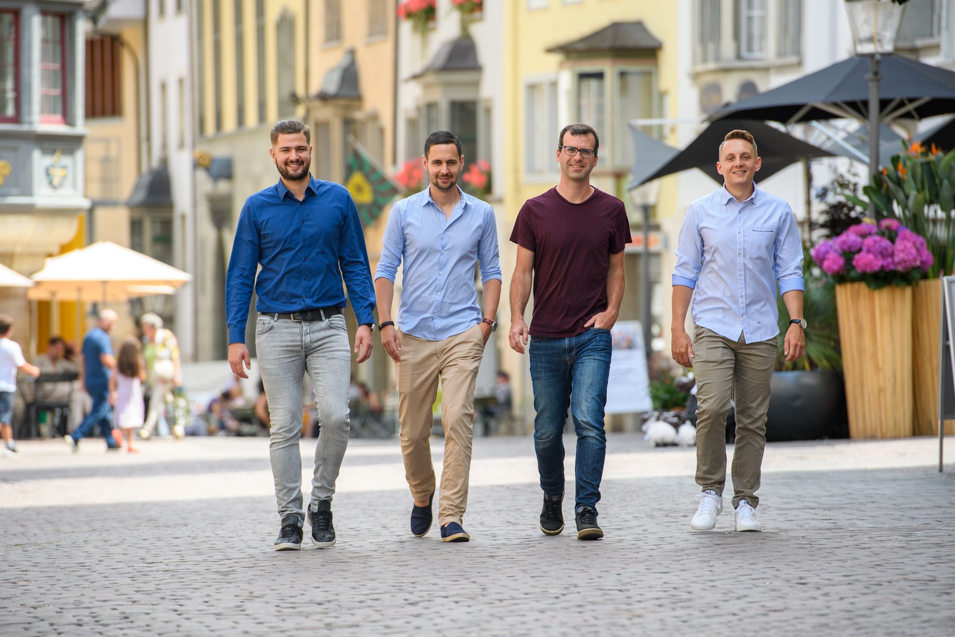 A group of men are walking down a cobblestone street.