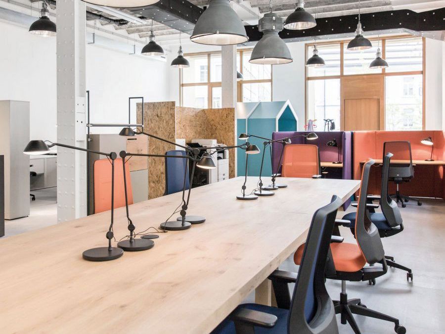 Ein grosses offenes Büro mit einem langen Holztisch und Stühlen.
