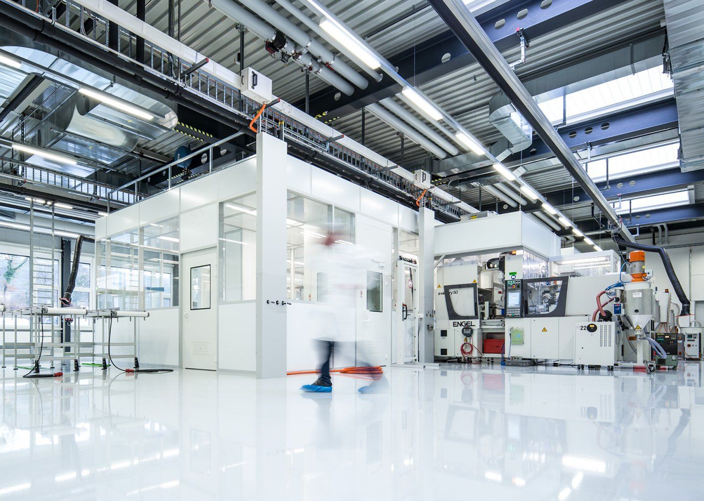 A man in a lab coat is walking through a factory.