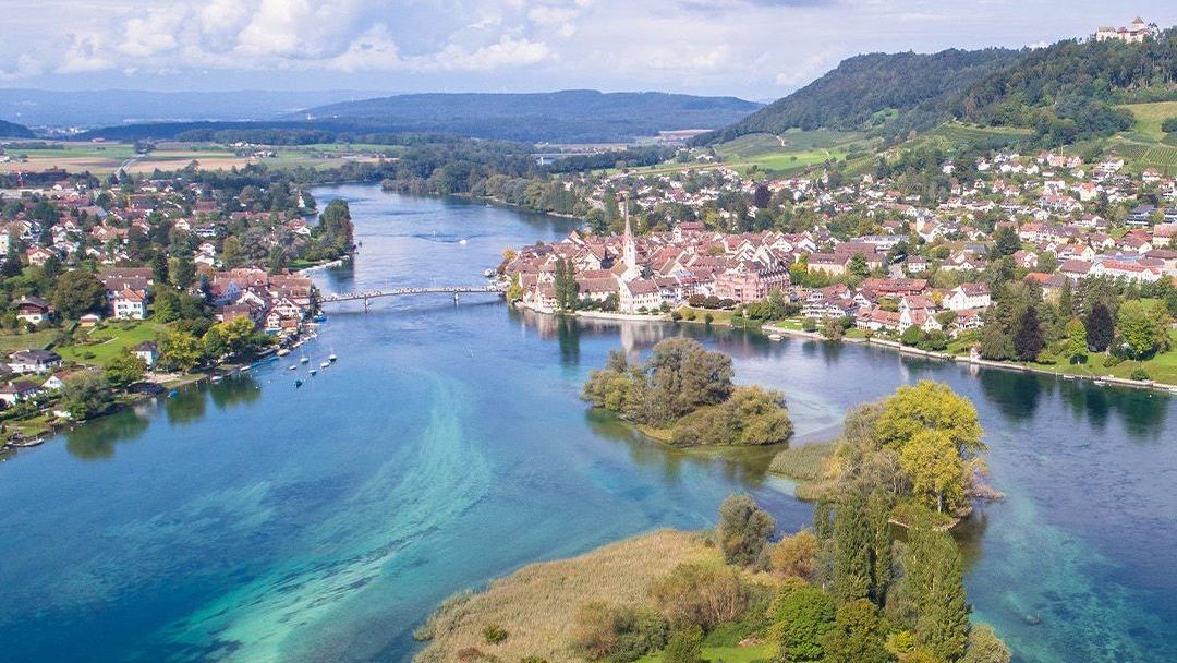 An aerial view of a lake with islands in the middle and a city in the background.