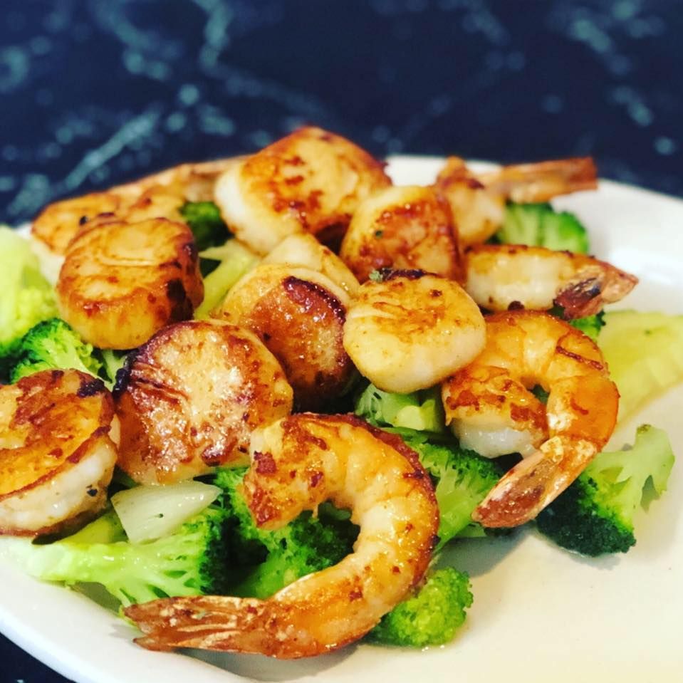 Grilled shrimp on broccoli and white rice with golden seared edges