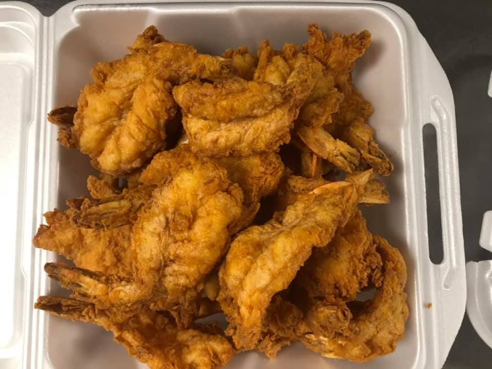 Tray of golden fried chicken pieces in a white takeout container