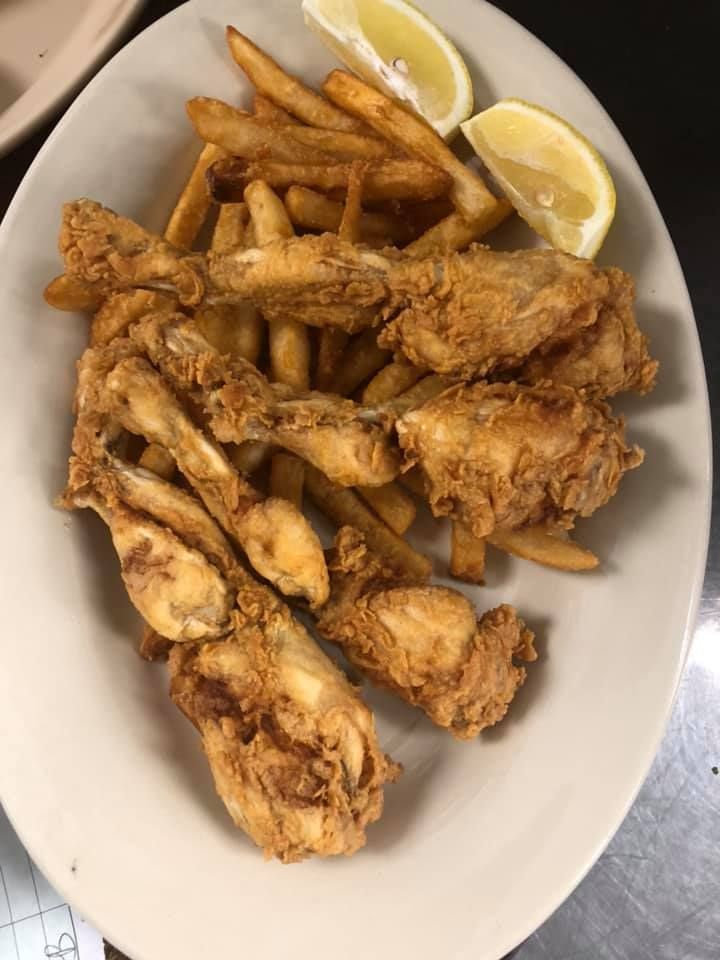 Plate of fried fish strips with lemon wedges on a white plate