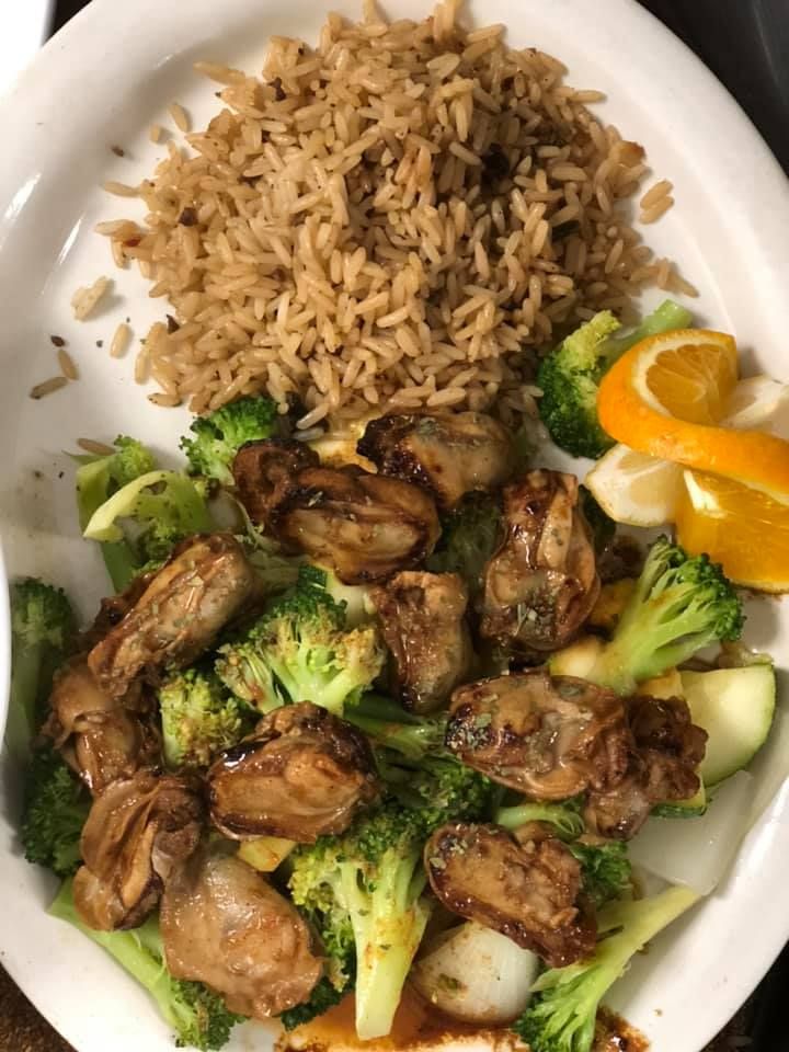 Plate with rice, grilled chicken, broccoli, onions, and orange slices.