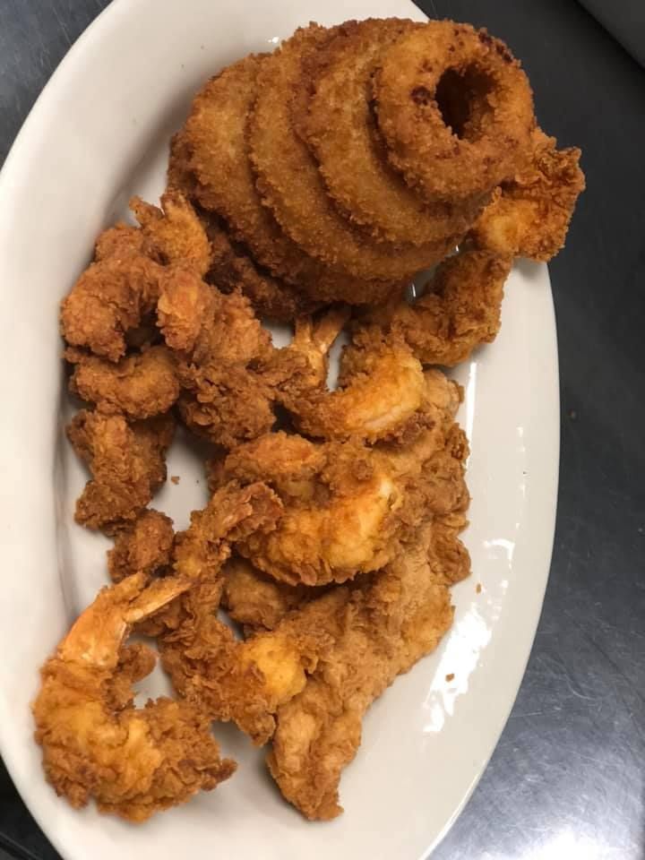 Plate of fried onion rings and crispy breaded chicken strips on a white dish