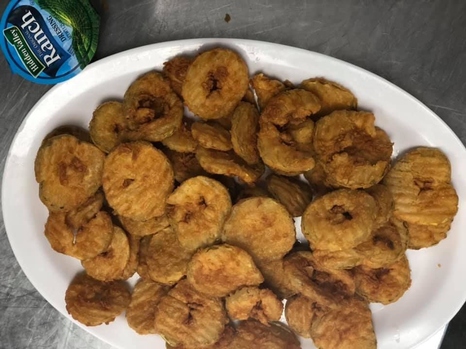 Plate of fried banana slices on a white dish with a blue-labeled cup at the top left.