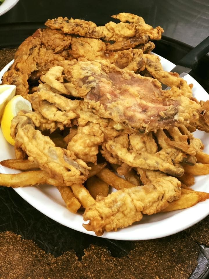 Plate of fried seafood and fries with lemon wedges on a table