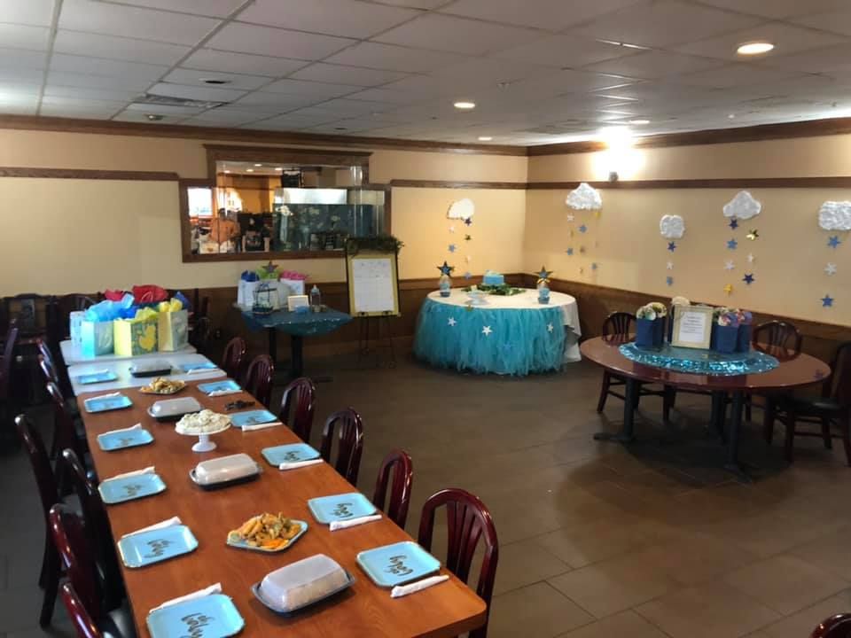 Decorated banquet hall with long buffet tables and round dining tables set for an event