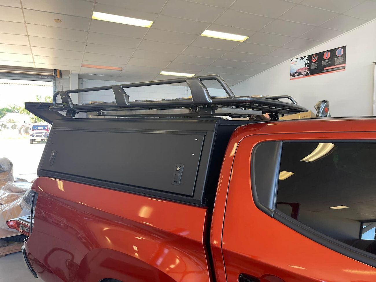 A Red Truck With a Black Roof Rack is Parked in a Garage — Whitsunday 4x4 & Automotive In Airlie Beach, QLD
