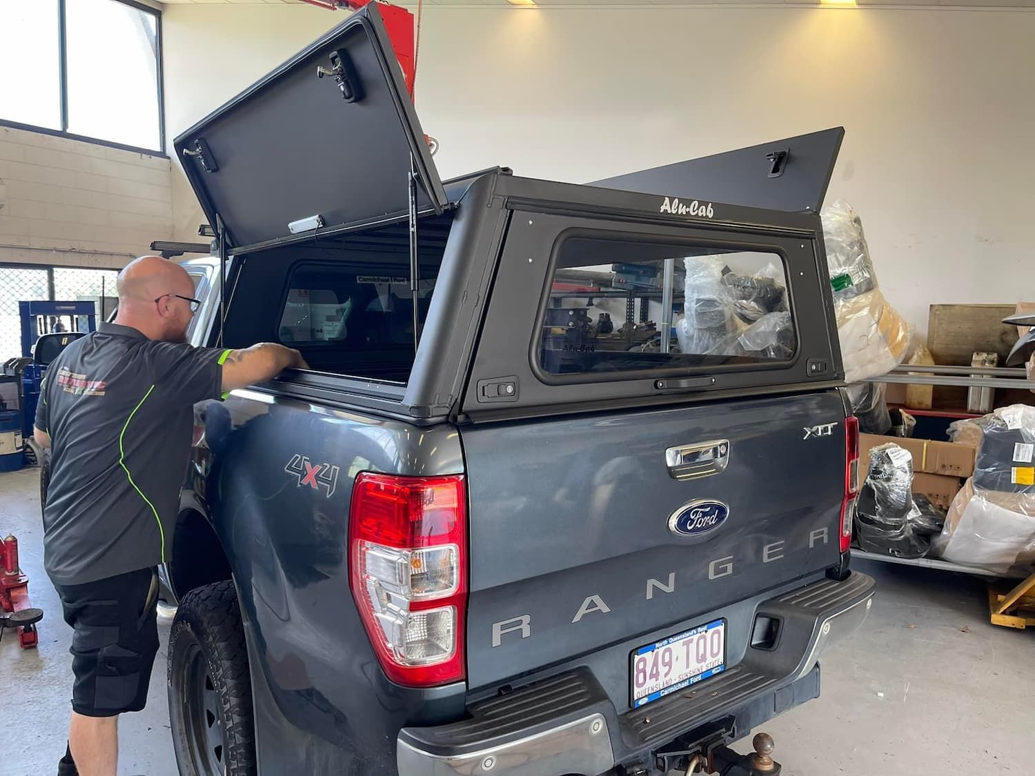 A Man is Working on the Back of a Ford Ranger Truck — Whitsunday 4x4 & Automotive In Cannonvale, QLD