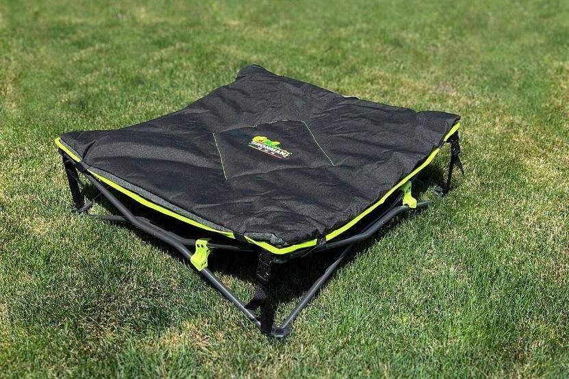 A black and yellow folding bed is sitting on top of a lush green field - Whitsunday 4x4 & Automotive In Cannonvale, QLD