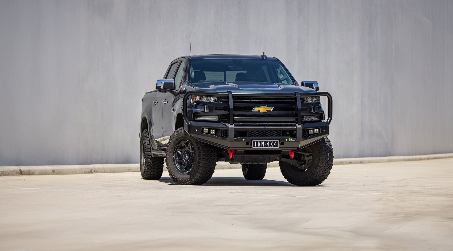 Black off-road pickup truck parked on a concrete lot against a plain gray wall. — Whitsunday 4x4 & Automotive In Proserpine, QLD