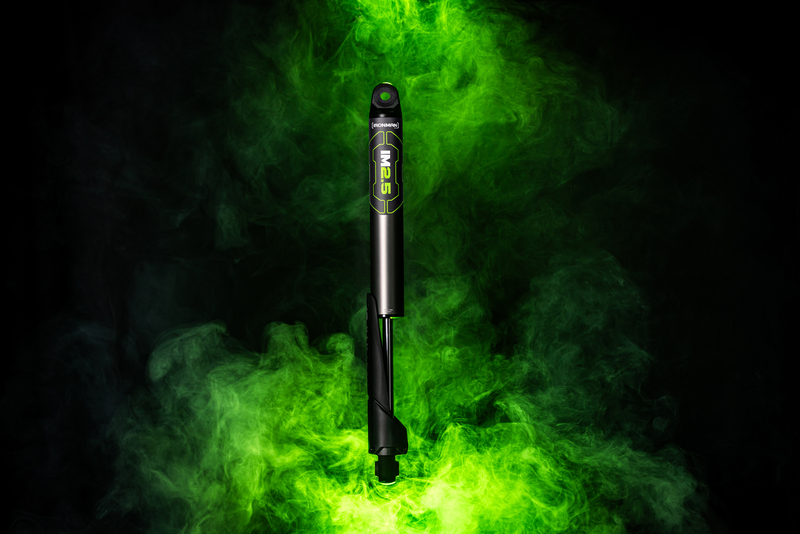 A pen is surrounded by green smoke on a black background.