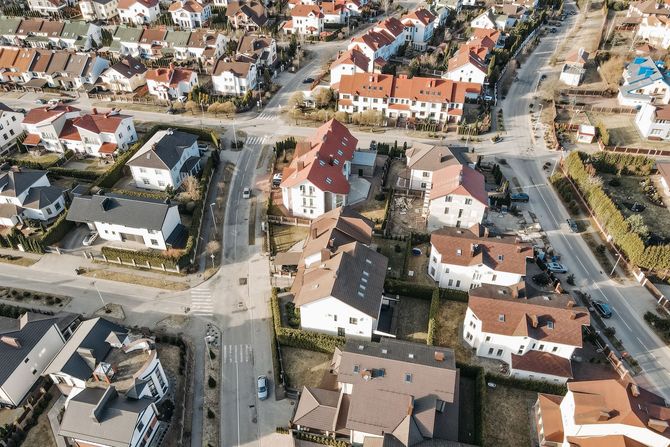Aerial view of a suburban neighborhood with houses, streets, and parked cars