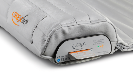 Gray portable medical cushion with an electronic control panel and orange logo on the side