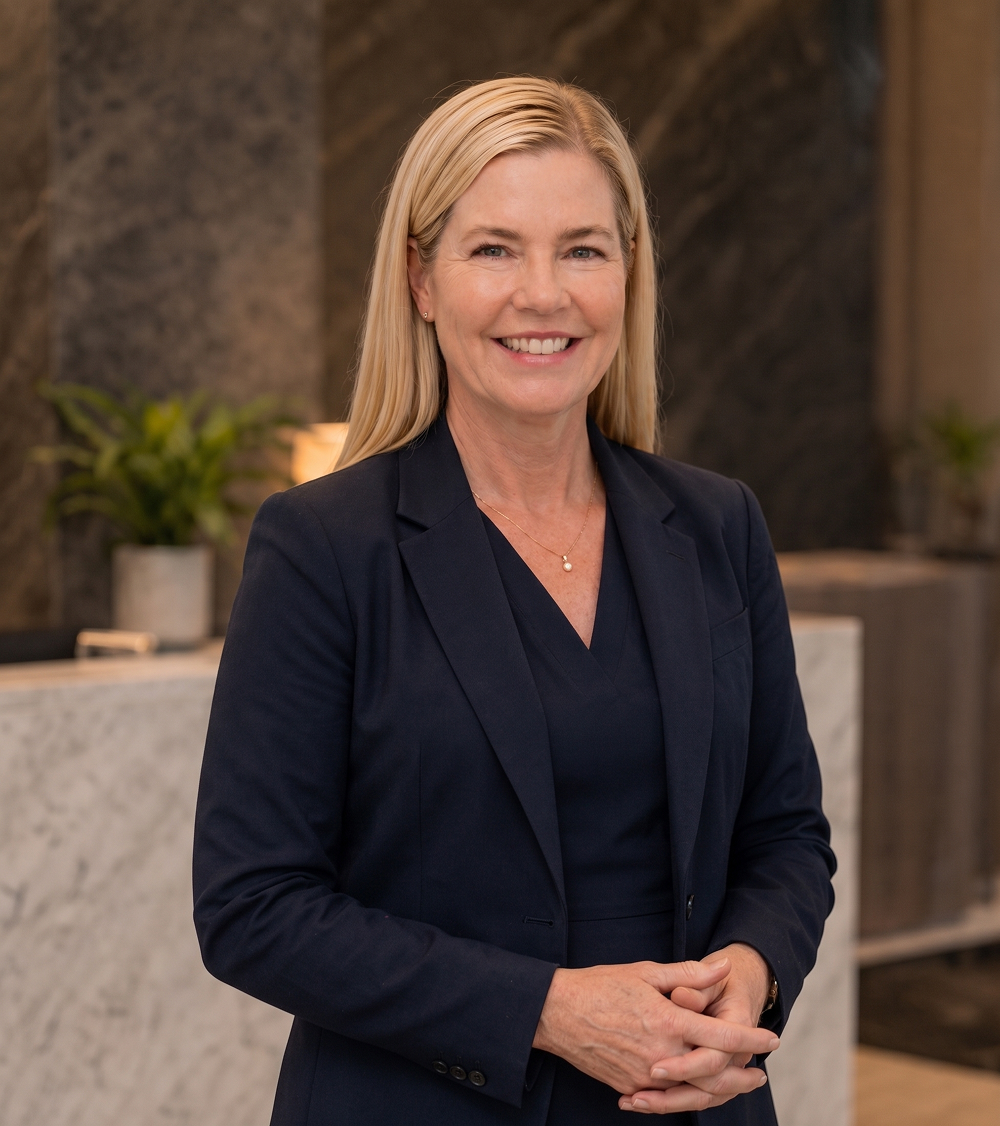 Smiling professional in a navy suit standing in a modern office lobby