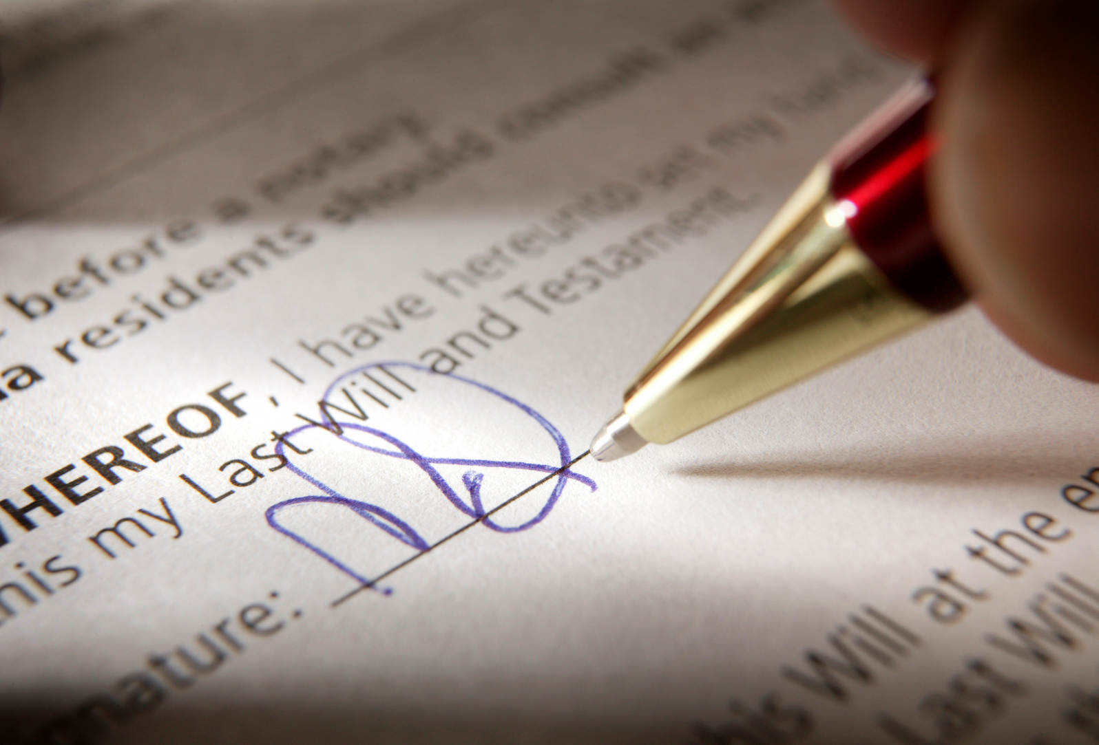 A person is signing a will with a red pen