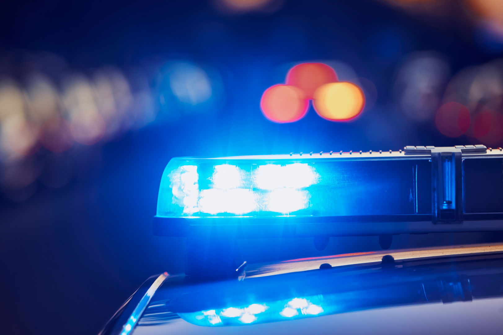 A close up of a police car 's blue lights at night.