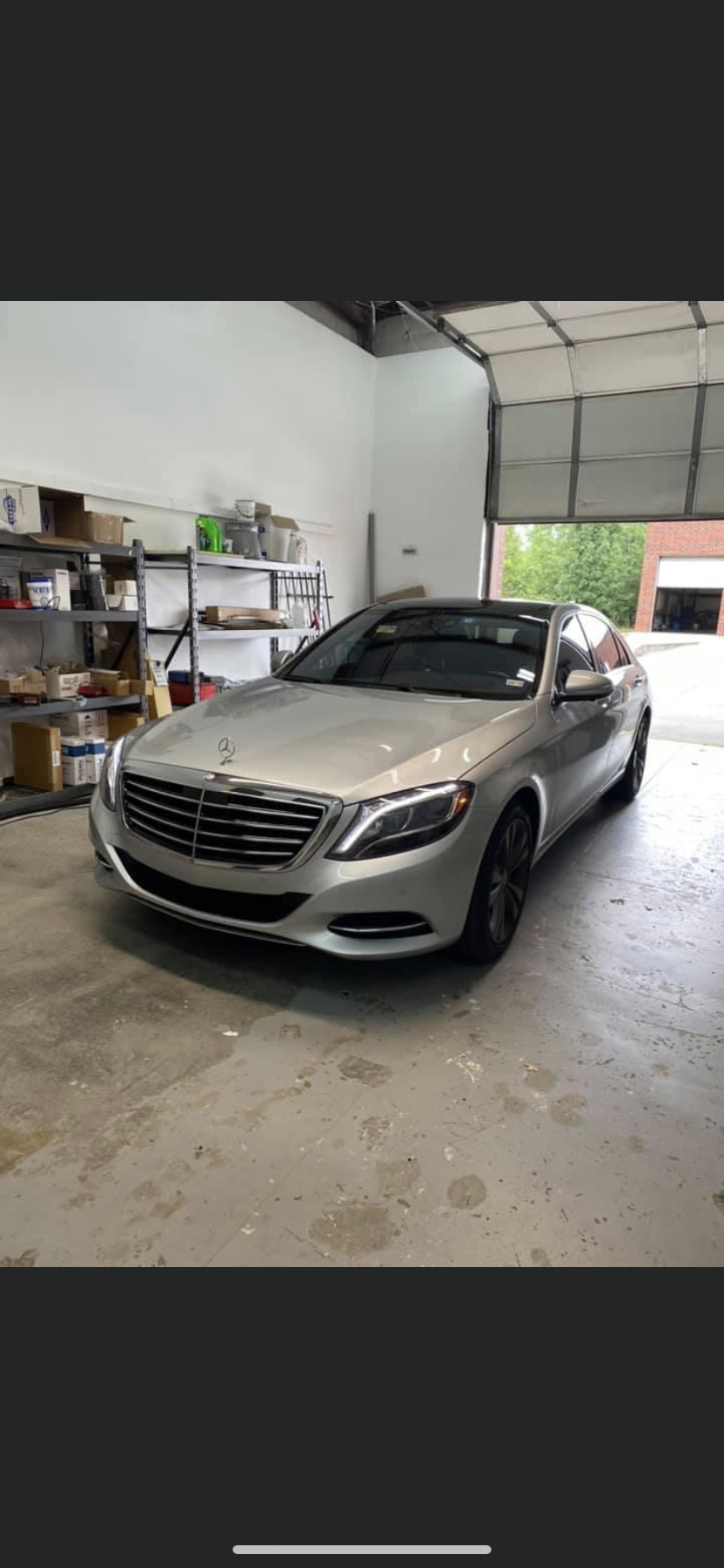 Silver Mercedes sedan parked inside a garage.