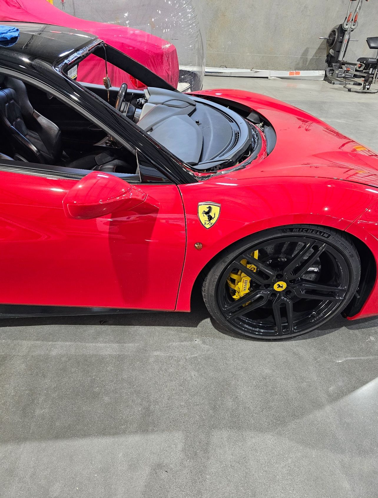 Red Ferrari sports car with black rims and yellow brake calipers.