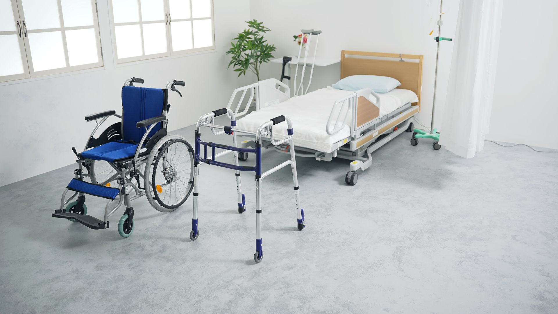 A hospital room featuring a blue wheelchair, a walker, and a hospital bed.