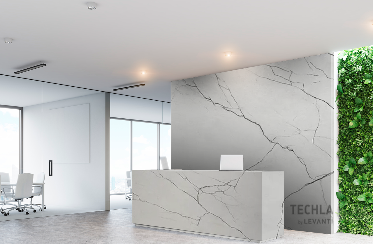 A reception area with a white counter and a green wall behind it.