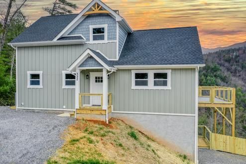 A gray house with a blue roof is sitting on top of a hill.