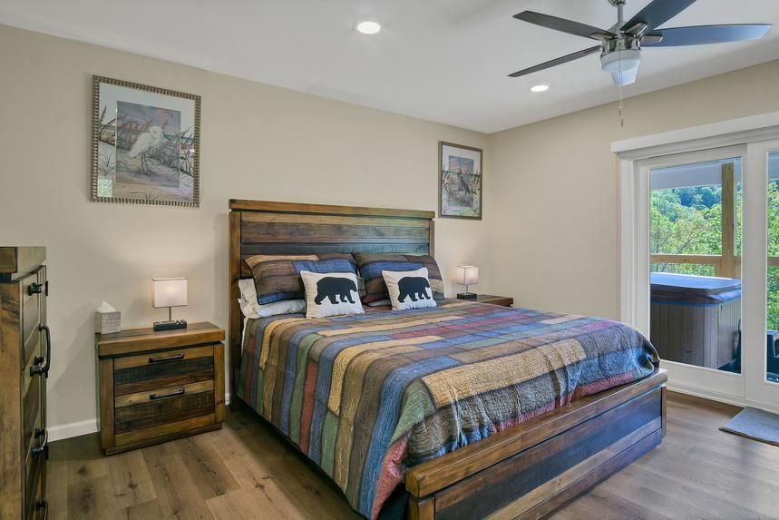 A bedroom with a king size bed and a ceiling fan.