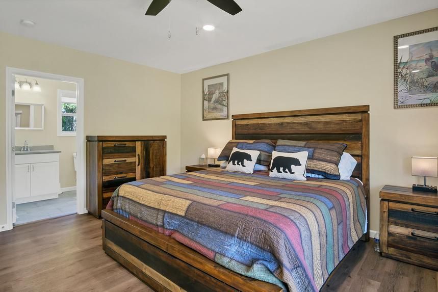 A bedroom with a king size bed and a ceiling fan.