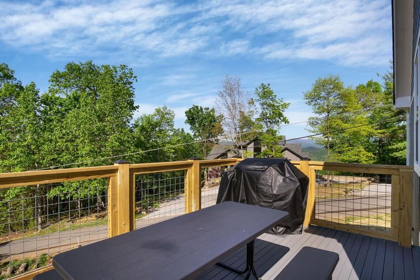 There is a table and a grill on the deck.