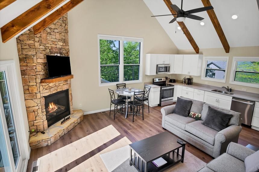 A living room with a fireplace , couch , table and chairs.