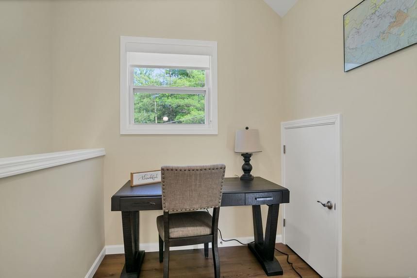 There is a desk and chair in the corner of the room.