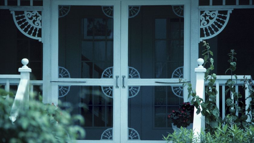 A screened in porch with a white railing
