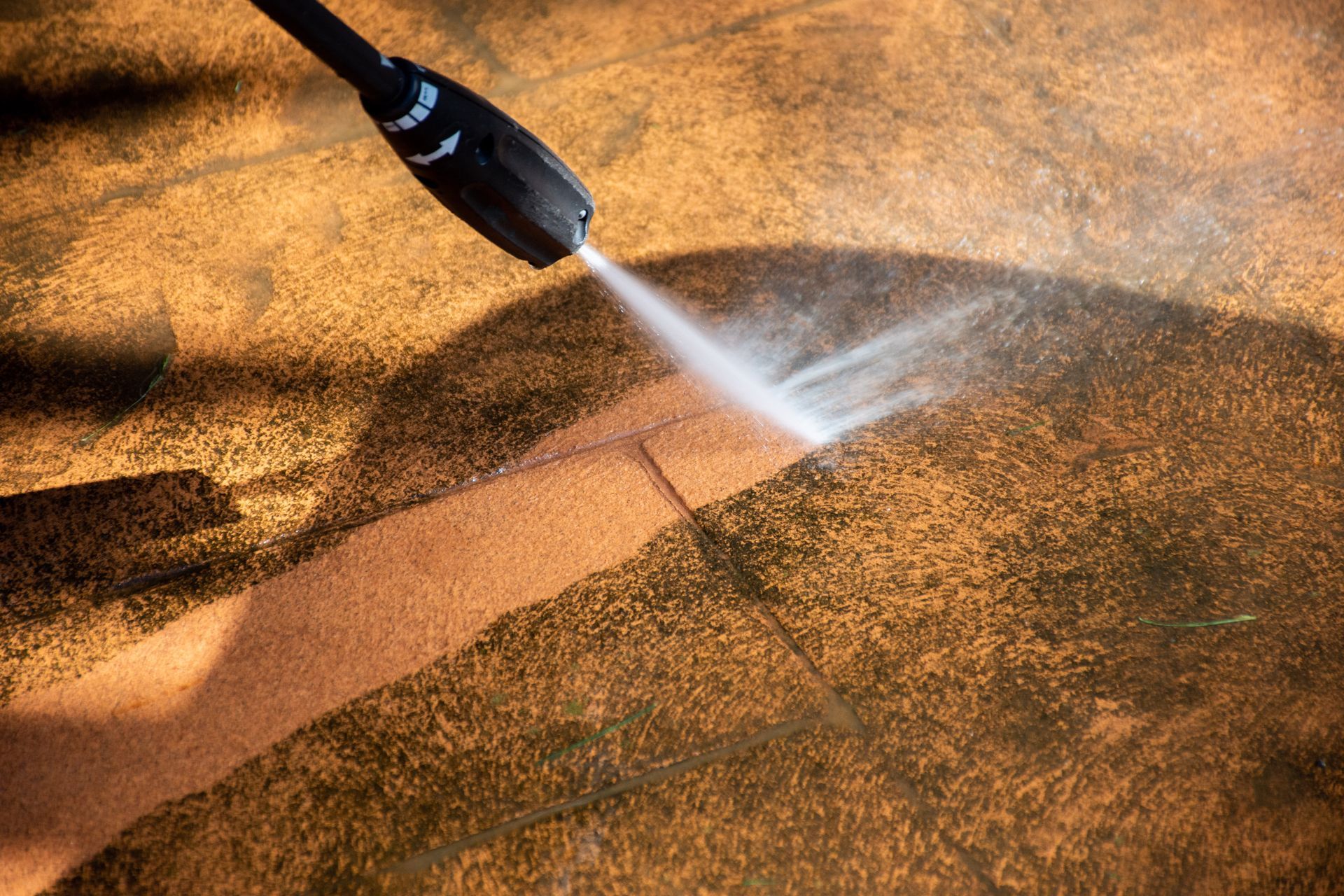 Close up of a power washer washing grime off of a sidewalk - amazing finish windows, tx