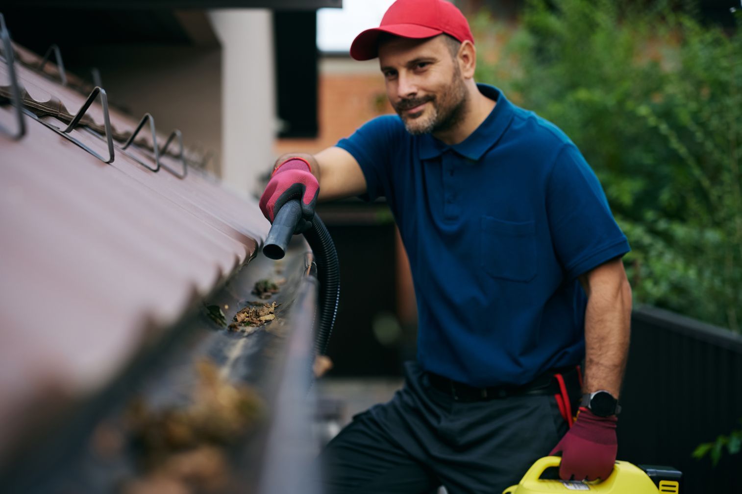 A professional is using a small leaf blower to clean gutters - amazing finish windows, tx