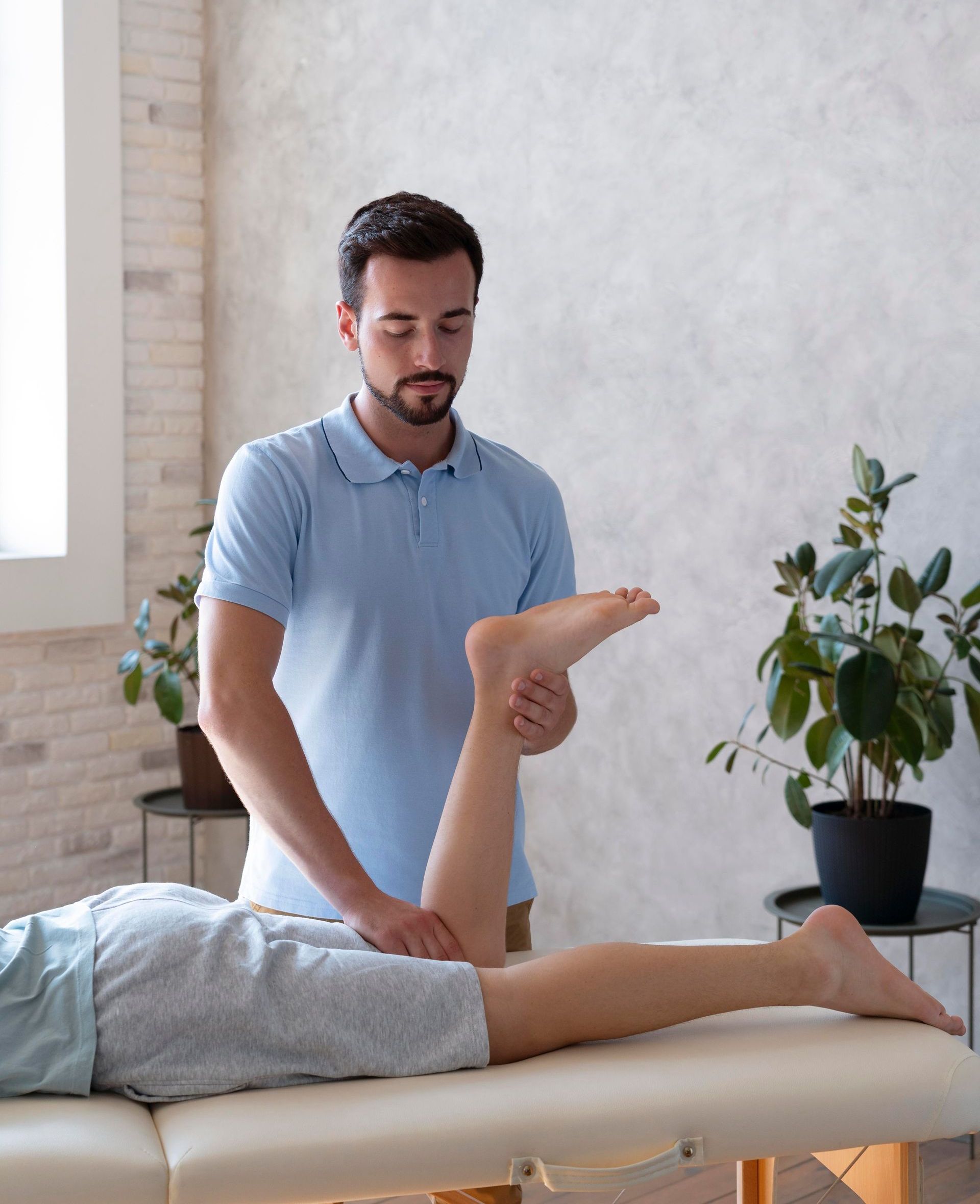 a man is stretching a woman 's leg on a table .