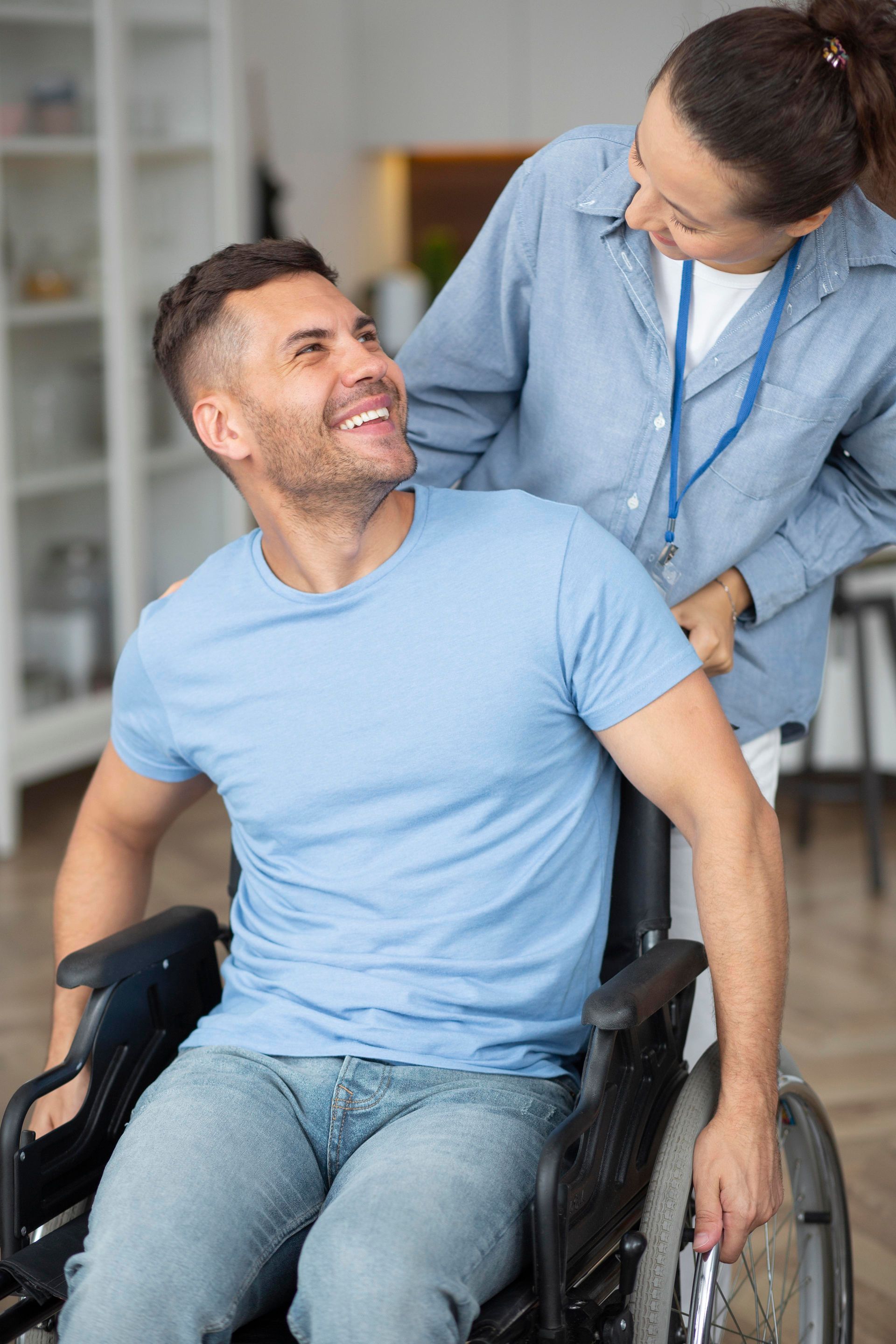 a woman is helping a man in a wheelchair .