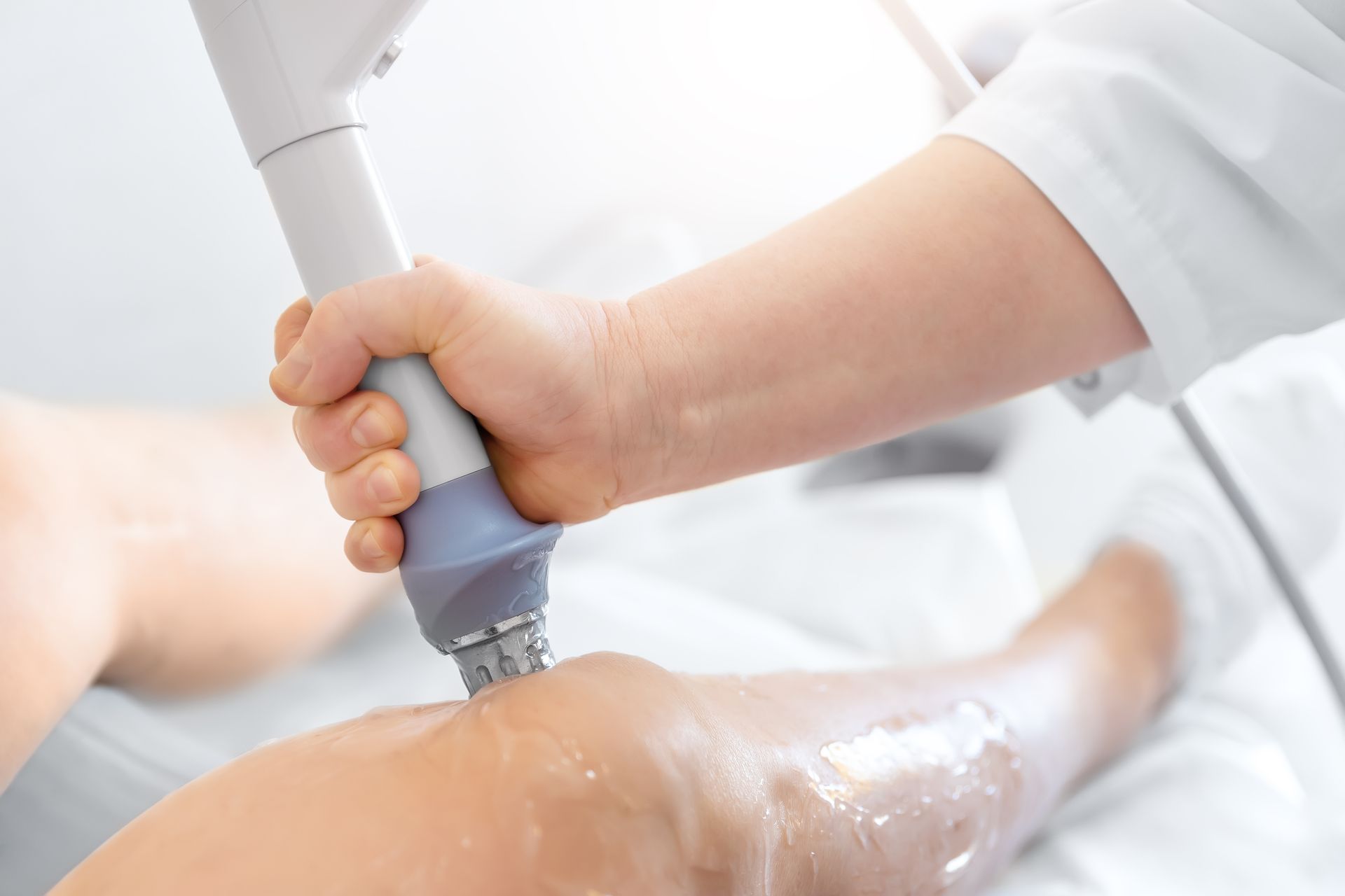 Medical procedure with a handheld device applied to a patient's leg