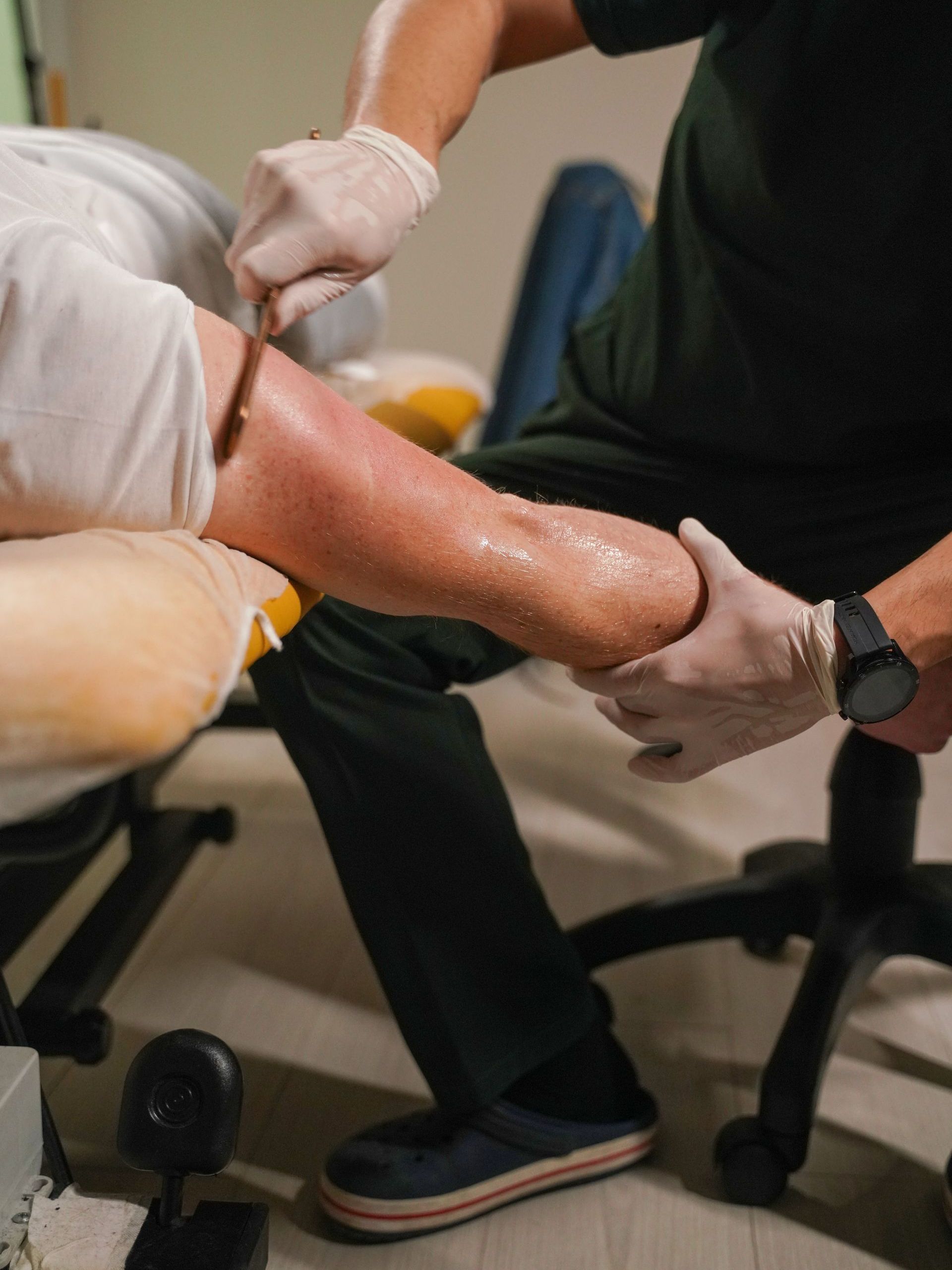 doctor using graston technique on leg