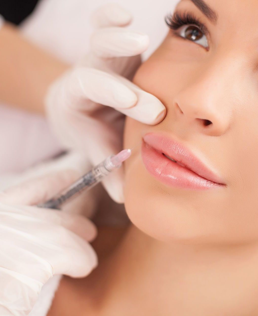 Woman receiving lip filler injection.