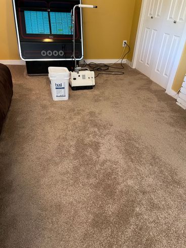 Carpeted room with a jukebox, bucket, and floor cleaning machine.
