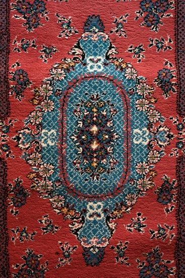 Red and teal oriental rug with a central medallion design and floral motifs.
