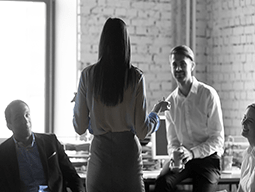 A woman is giving a presentation to a group of people in an office.