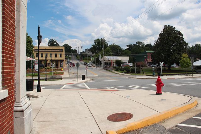 A red fire hydrant sits on the corner of a street