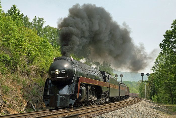 A train is going down the tracks with smoke coming out of it