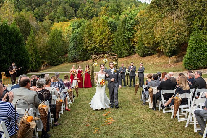 A bride and groom are walking down the aisle at their wedding