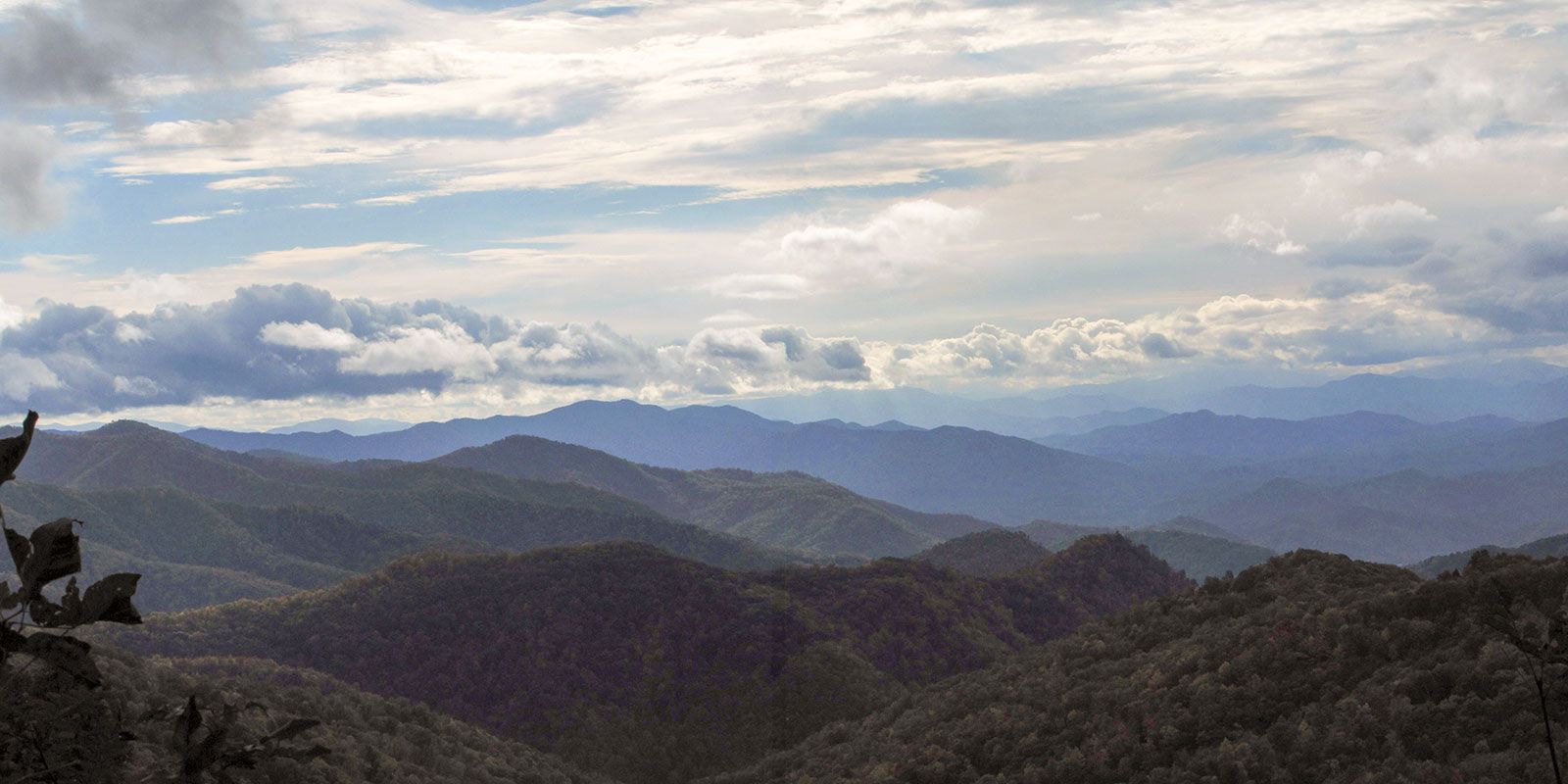 A view of a mountain range with clouds in the sky